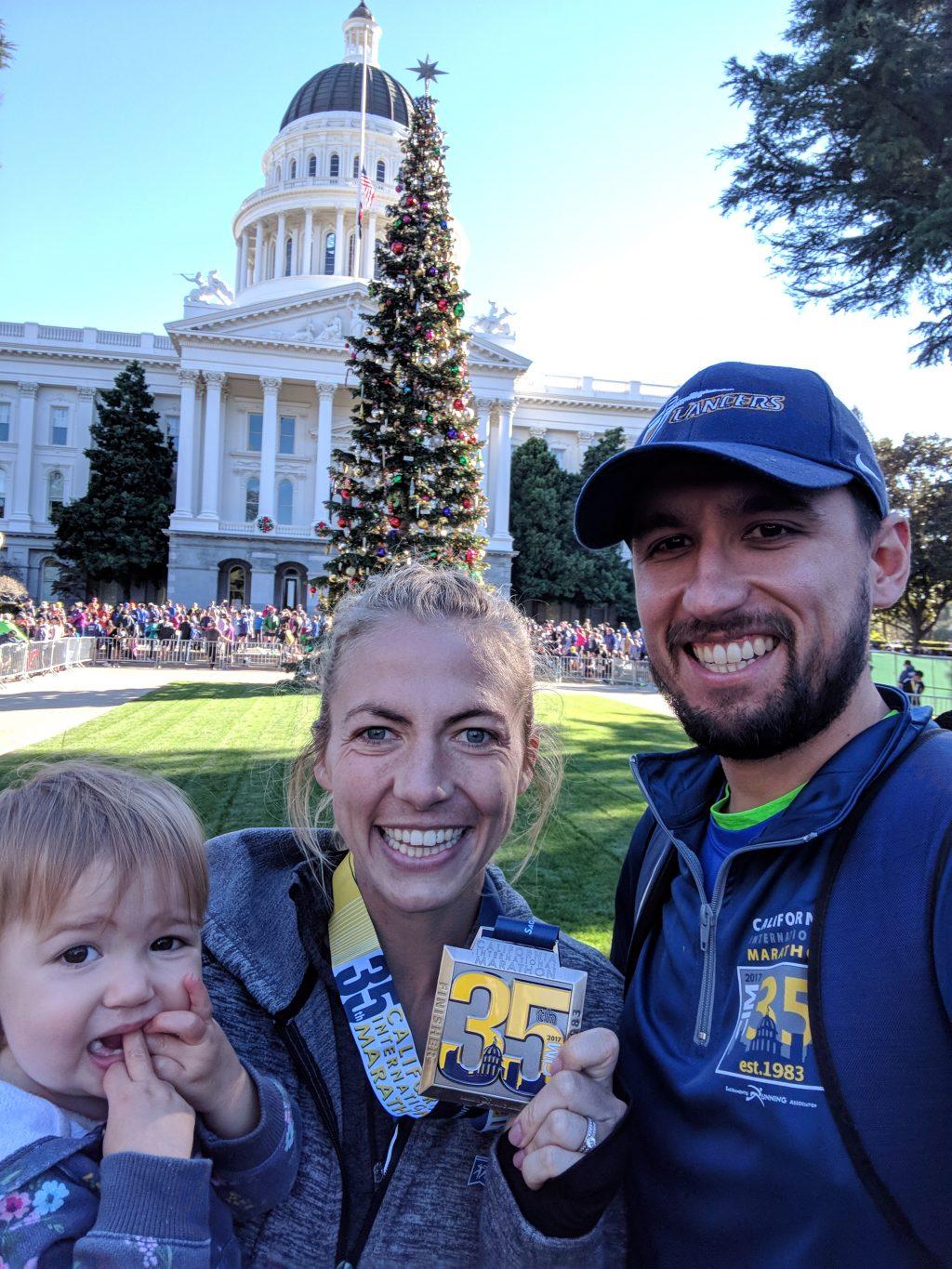 Floris, flanked by her daughter Liv and husband Henri, shows off her CIM medal in front of the California State Capitol in Sacramento. Floris' 2017 CIM race remains her personal best in a marathon.