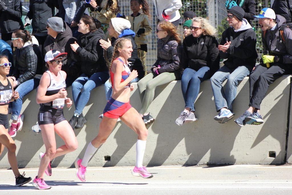 Floris (red-and-blue shorts) races the Olympic Trials Marathon in Atlanta as a large crowd cheers her on.