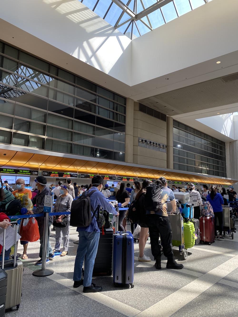 Travelers stand in line with their luggage inside the Los Angeles International Airport on Aug. 16 at 10:35 a.m. They waited to check in their suitcases and receive their boarding passes.