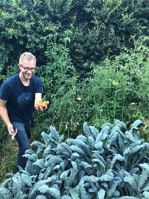 Professor Jeffrey Schultz smiles in his ever-expanding garden. Schultz said working outside is a meditative experience. Photo courtesy of Jeffrey Schultz