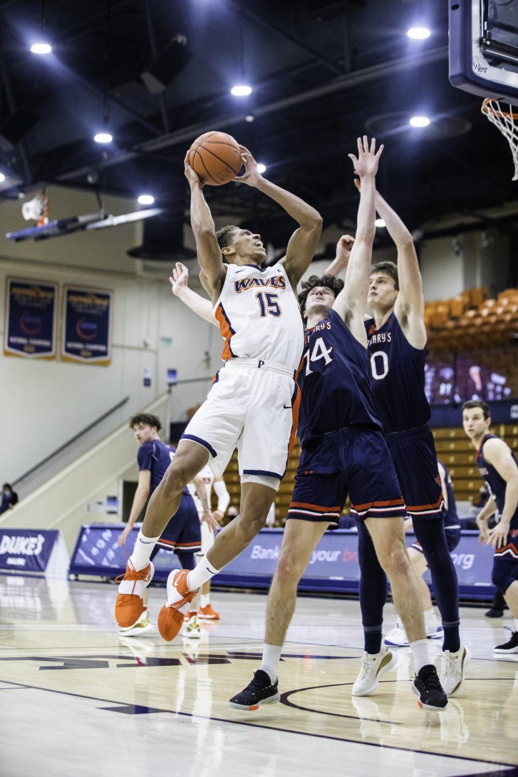 Junior forward Kessler Edwards (No. 15) goes up for a contested layup against sophomore forward Kyle Bowen (No. 14) and freshman center Mitchell Saxen (No. 10). The forward scored 15 points and grabbed 5 rebounds.