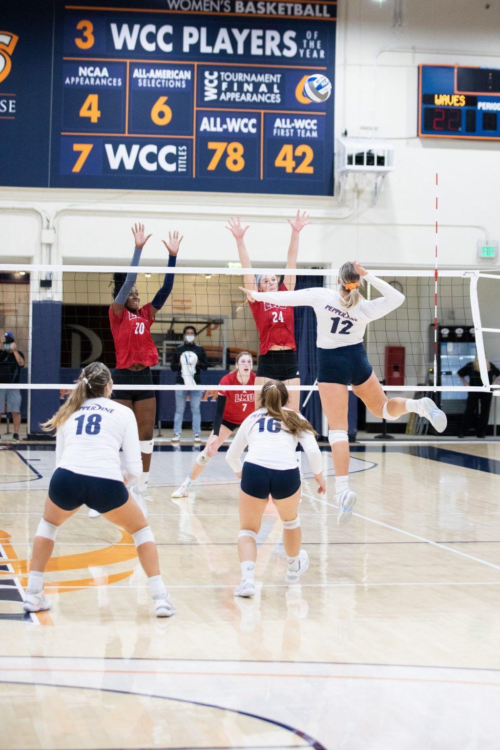 Sophomore middle blocker Meg Brown goes for a spike against LMU blockers Oct. 2. The Waves have a six game win streak, with Brown starting each match.