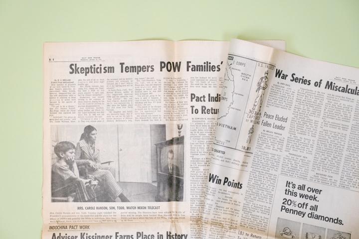 A newspaper is flipped open to an article about
families’ skepticism about the release of their
family members who were prisoners of war in Vietnam.