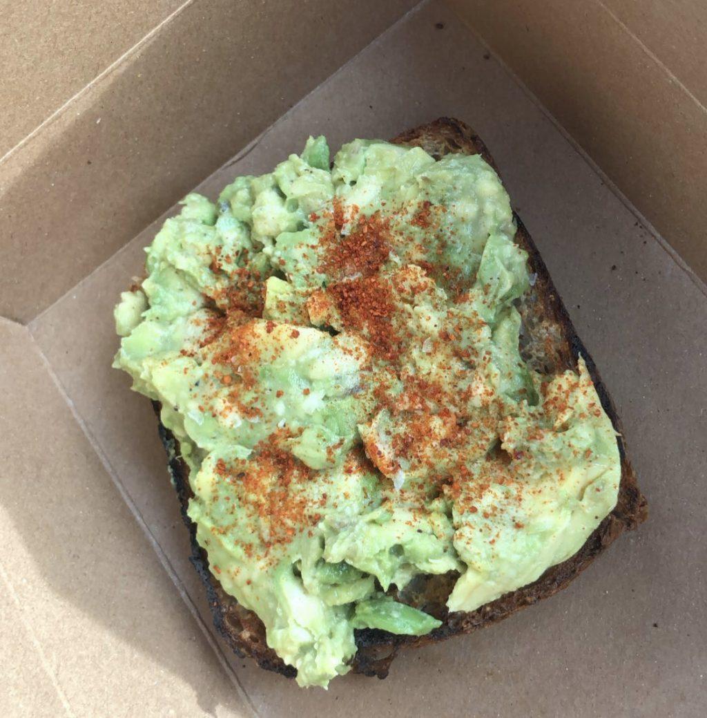 Avocado toast from Blue Bottle takes a more traditional approach with mashed avocado on sourdough bread. It is garnished with a sprinkle of paprika.