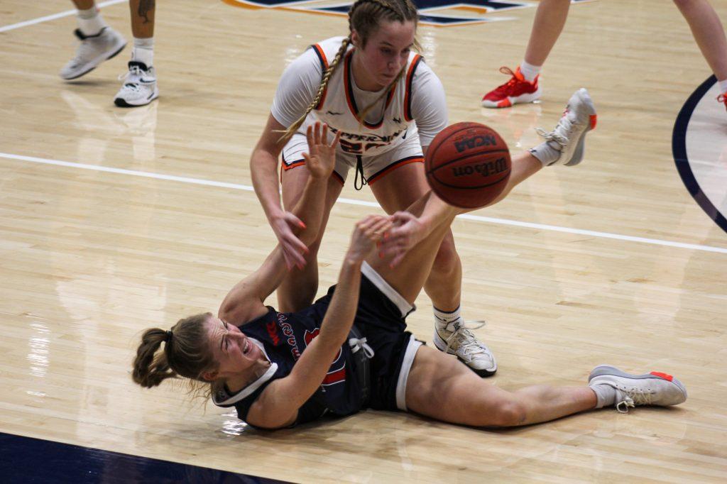 Redshirt junior forward Eve Brasilis (white jersey) battles with a Saint Mary's player (blue jersey) for the ball during the Waves' win at Firestone Fieldhouse on Jan. 31. Both teams played physically throughout the contest.