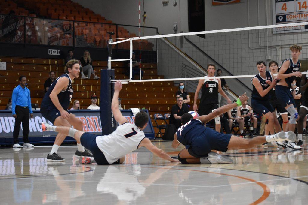 Senior Libero Spencer Wickens and Jaylen Jasper dive for possession.  The Waves had 26 digs in the game.  Photo of Marie Elisabeth