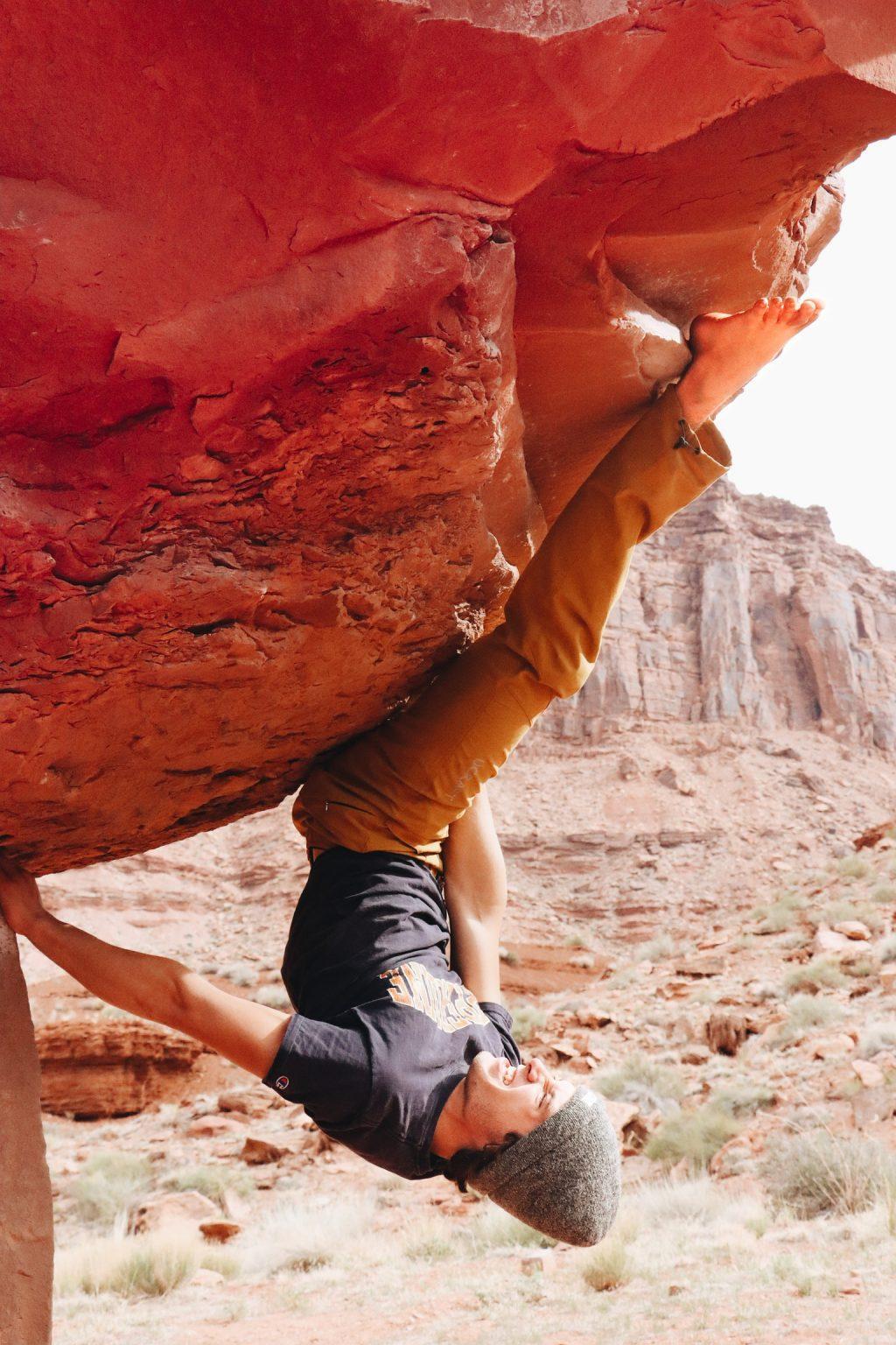 Climbing Club President junior John Palmer contorts his body upside-down on a bouldering route near Moab, Utah in April, 2021. Palmer has been president of Climbing Club since Fall 2021. Photo by Sammie Wuensche