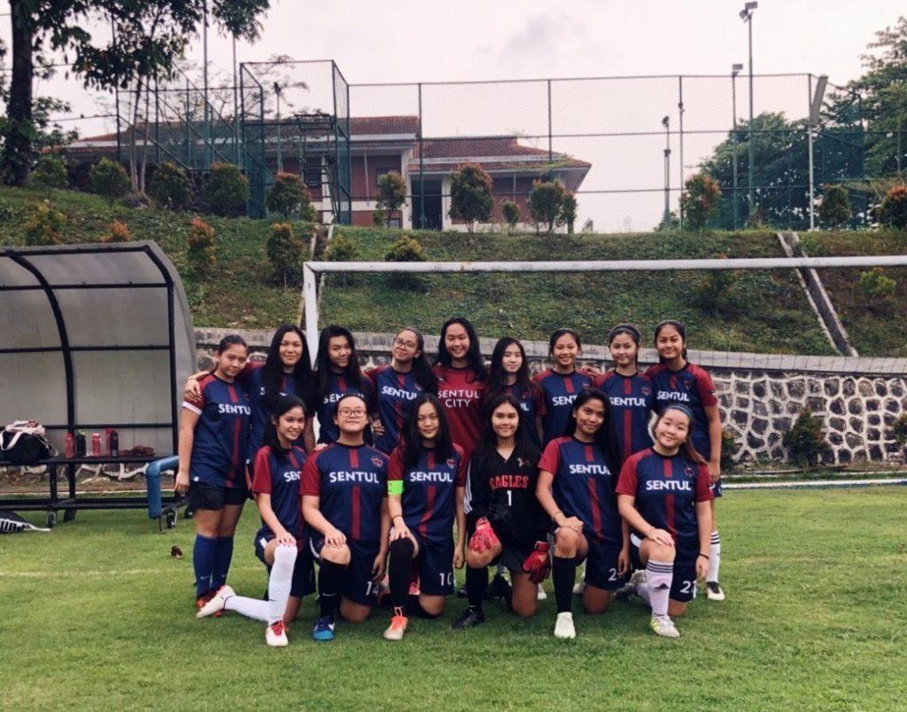Putri (front row, third from left) kneels with her soccer teammates for a group portrait. During her middle and high school years, Stella spent her time playing soccer.