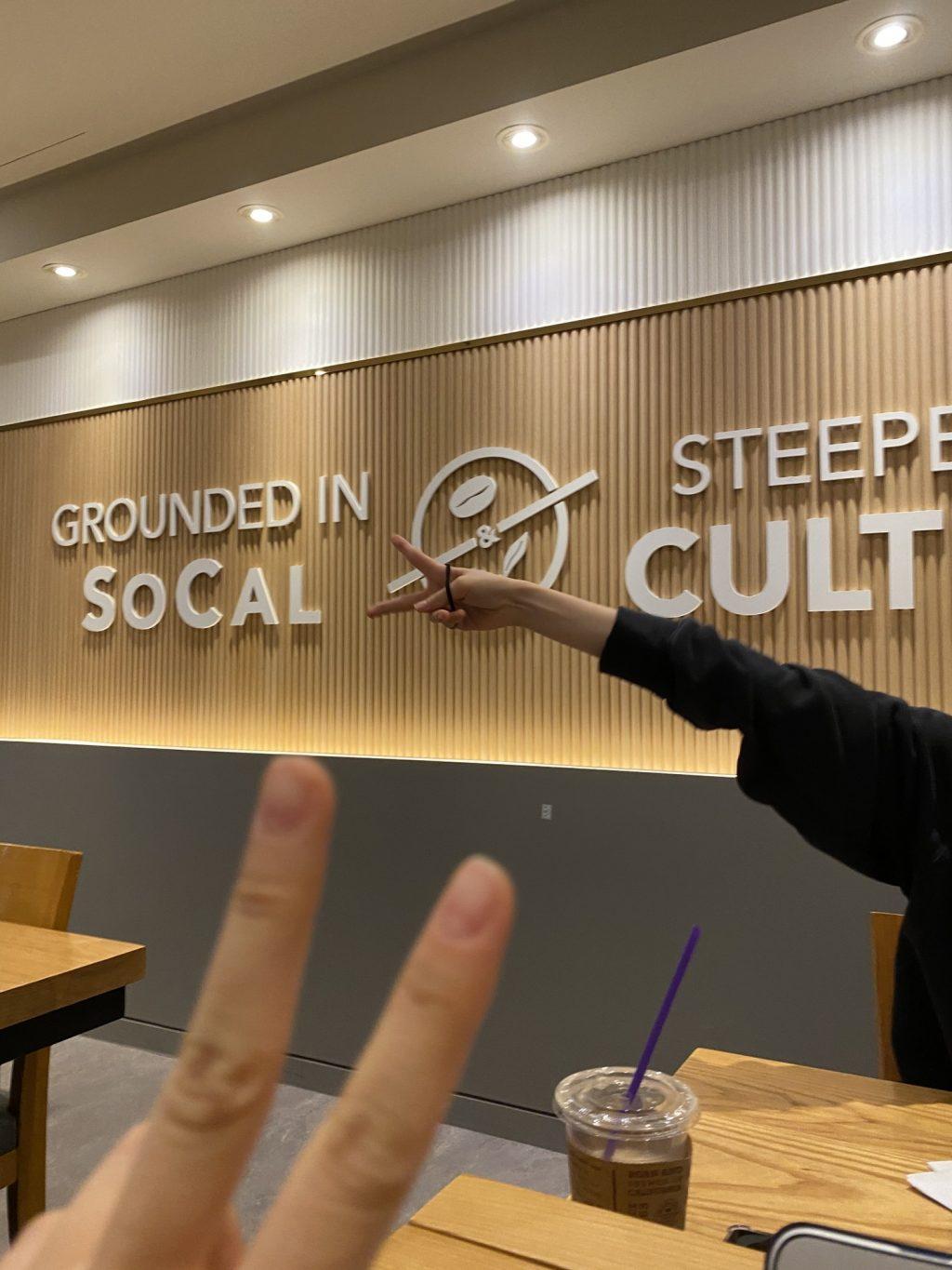 My roommate and I hold up peace signs while taking a break from our online studies at a local Coffee Bean on Oct. 24. I was reminded of home with the "Grounded in SoCal" sign on the wall and the American music playing inside. Photo by Claire Lee