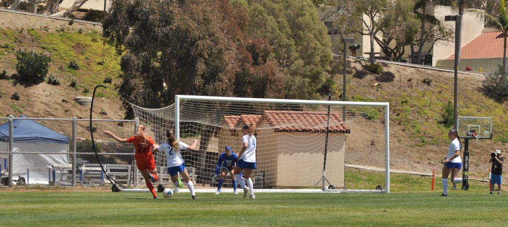 Junior midfielder Leyla McFarland (in orange) shoots and scores during Saturday's match against BYU. McFarland converted her chance, but the Waves missed several other opportunities to score in a 2-1 loss.