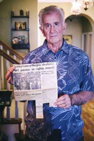 John Skelly hold a newspaper clipping headlining his involvement in the Selma march. 