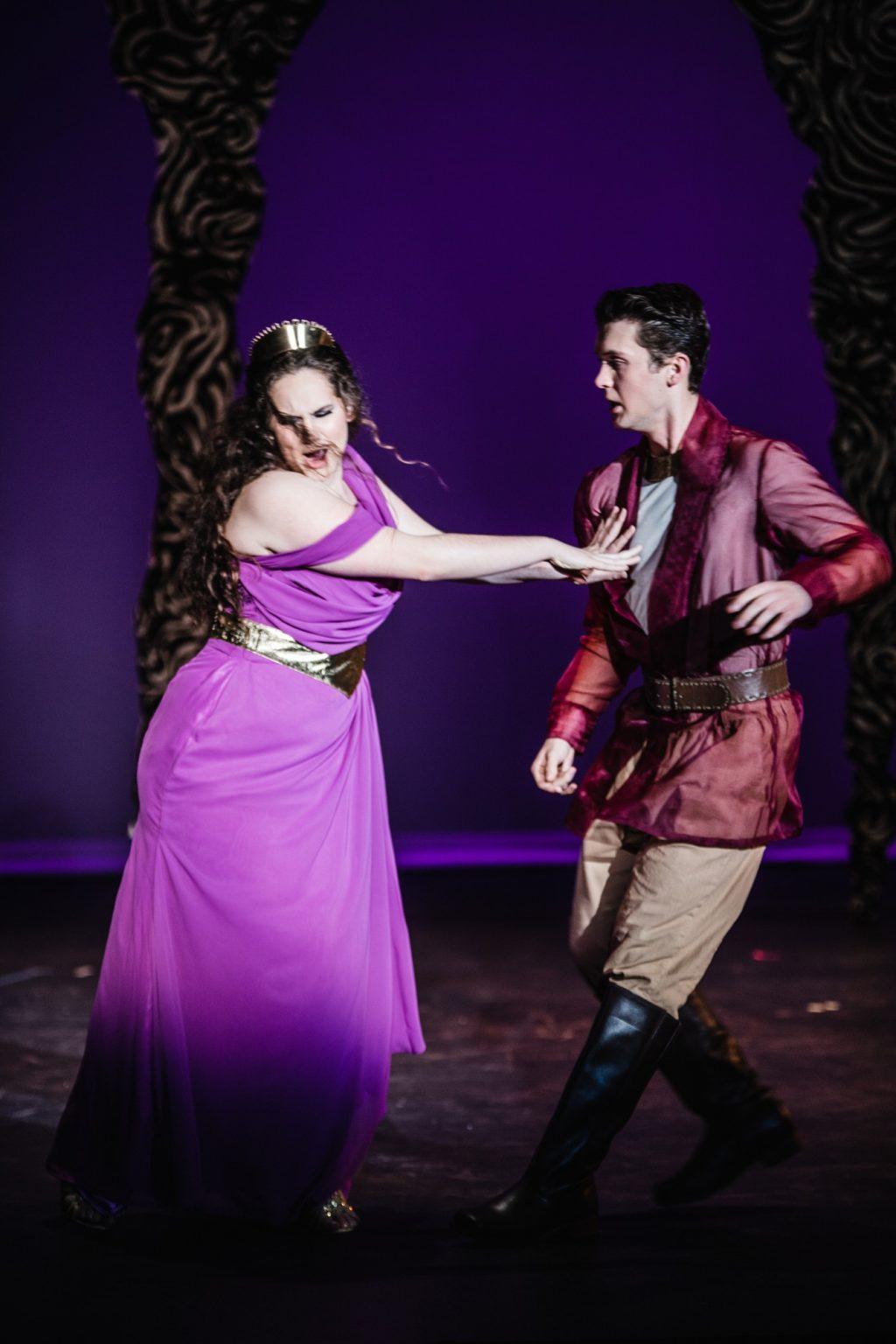 Dido, Queen of Carthage (Withers), pushes away her Greek love Aeneas (Joe Hebel). The opera follows the tragic journey of the couple's struggle between love and prophesy.