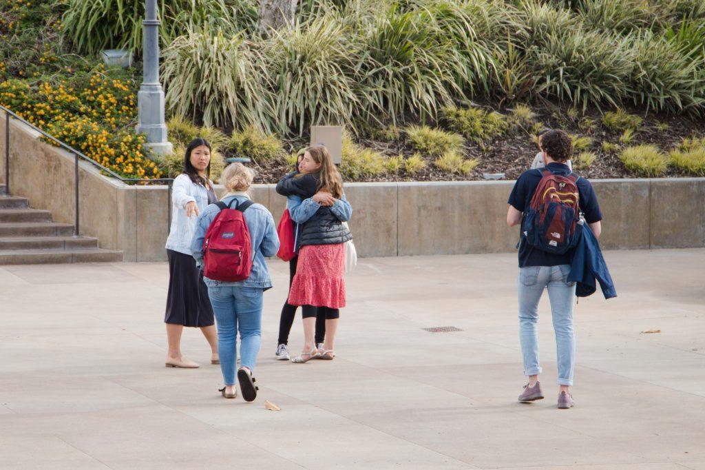 Students embrace one another after learning they must move out of their on-campus housing by Sunday, March 15.