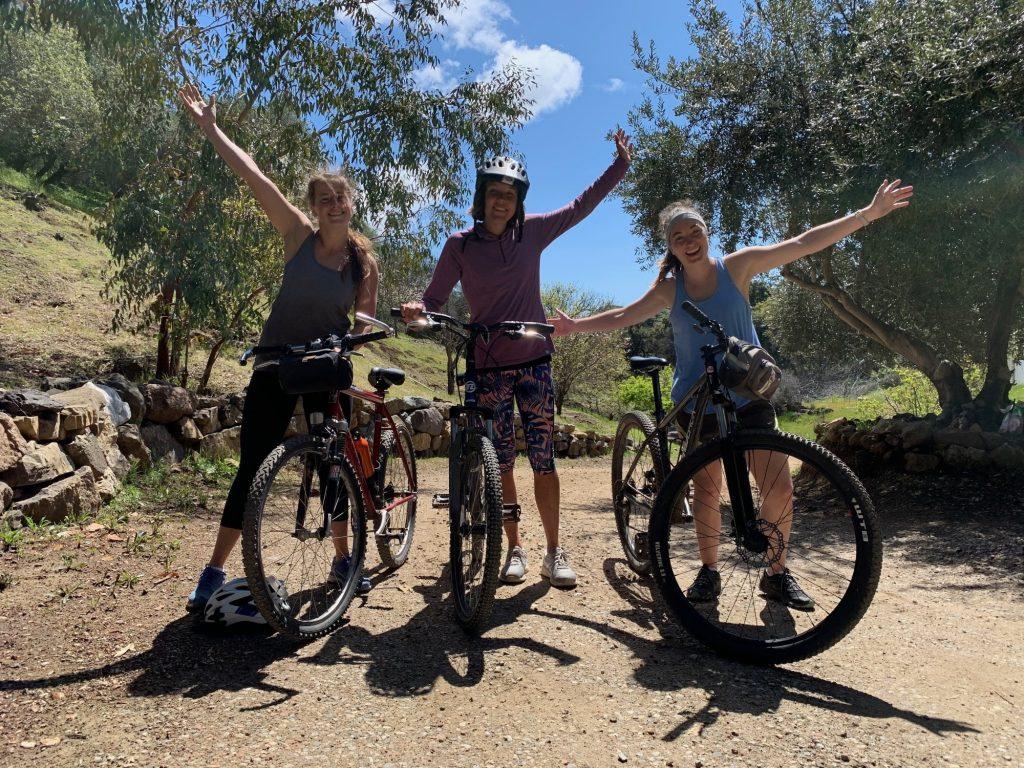 Off-campus seniors Grace Palmer, Cori Persinger and Kelsey Harmon, who are quarantining together, bike on a trail near Calamigos Ranch during campus closure.