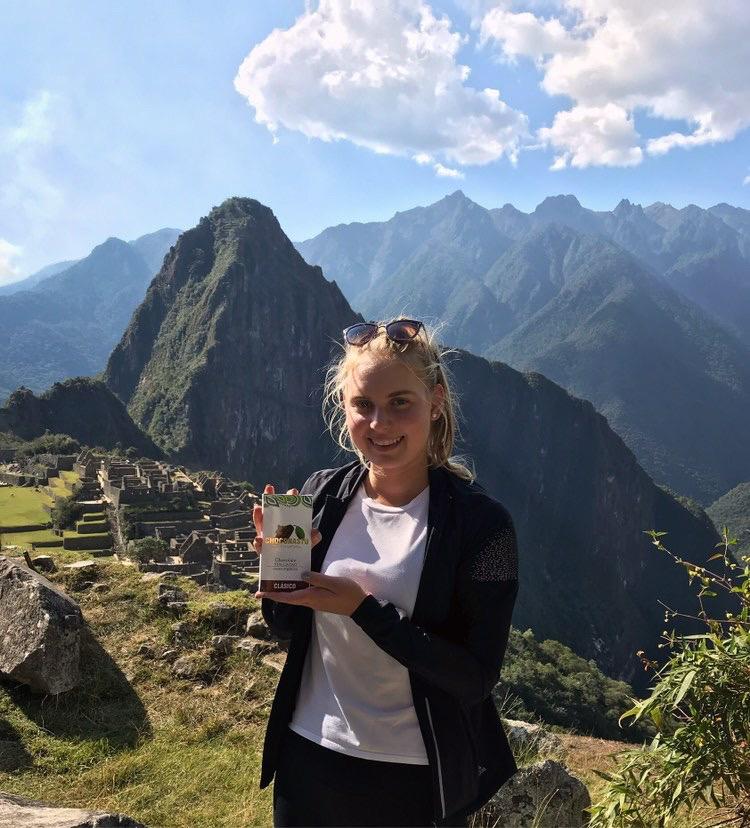 Chocolatier and founder Anastasia Lamachkine shows off her Choconastu chocolate bar atop Machu Picchu, Peru. Her chocolate is made with organic cacao beans from Tingo Maria, a city located in the Peruvian rainforest. Photo courtesy of Anastasia Lamachkine