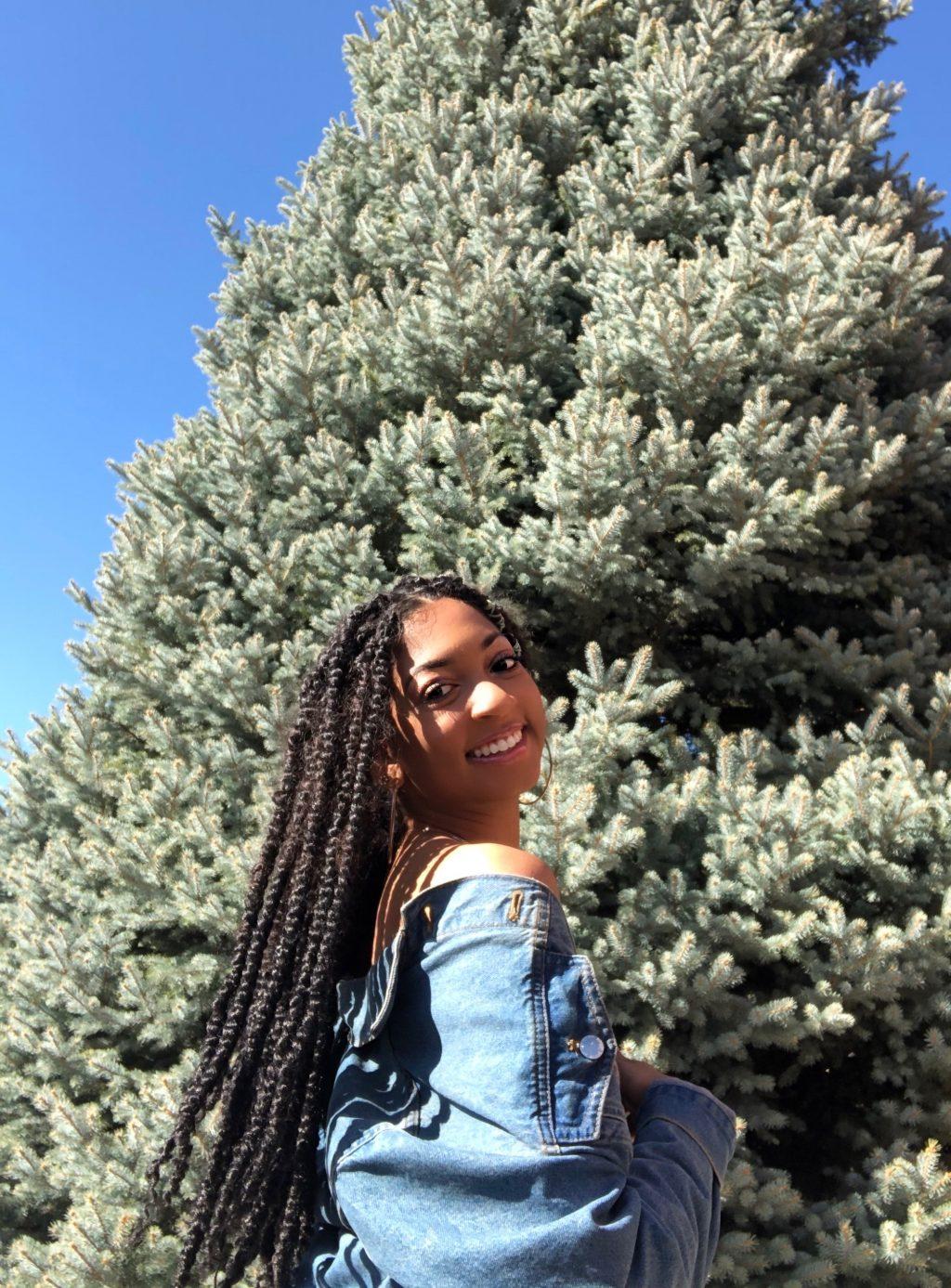 Pearson peaks over her jean-clad shoulder for a photo on her family's property. Originally enrolled as a Journalism major, she switched to a Biology major to become a physical therapist.