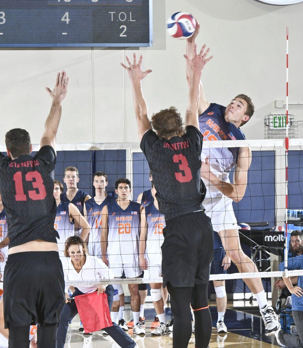 Pepperdine outside hitter David Wieczorek takes a swing against two Stanford blockers in a Feb. 8, 2019 MPSF match at Firestone Fieldhouse. Photo courtesy of Pepperdine Athletics