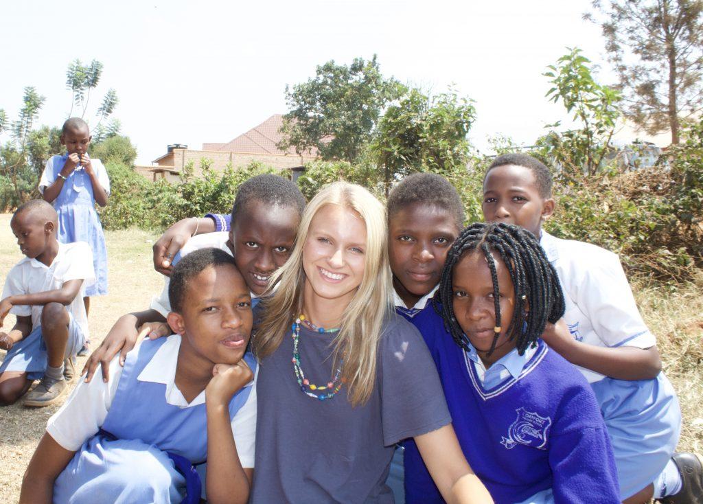 Davis smiles with children in Kigali, Rwanda, during one of her mission trips in the summer of 2019.
