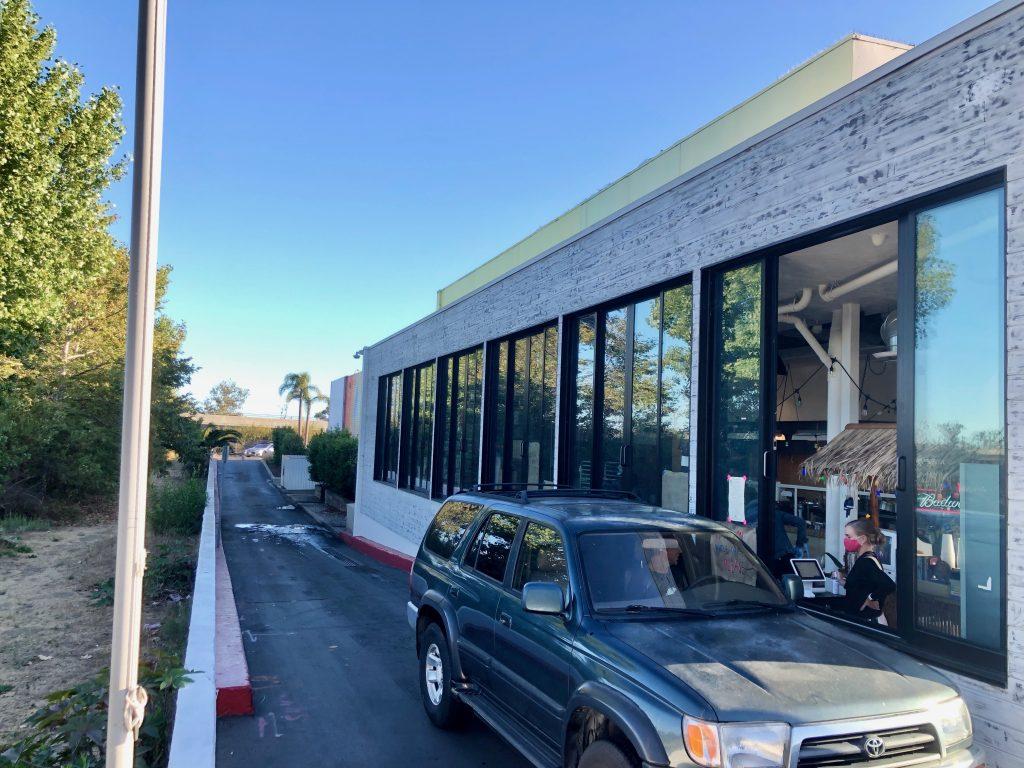 A patron orders and picks up his food from inside his car at Broad Street Oyster Company's recently opened drive-thru window.