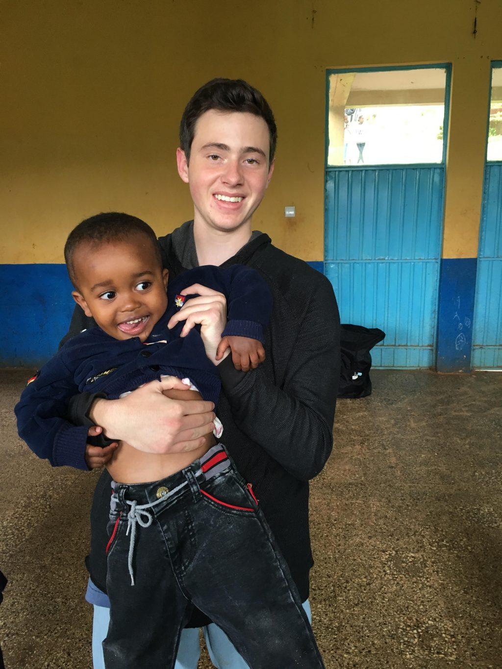 Ishak smiles with an Ethiopian child at an orphanage. He visited the country on a medical mission trip with his family.