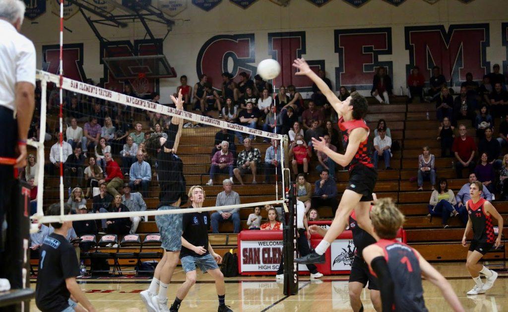 Freshman opposite Eli Crane spikes the ball during a high school match. Crane has been separated from his fellow freshmen teammates, as he lives in "The Stinkies" apartments, but is not allowed to go on campus. Photo courtesy of Eli Crane