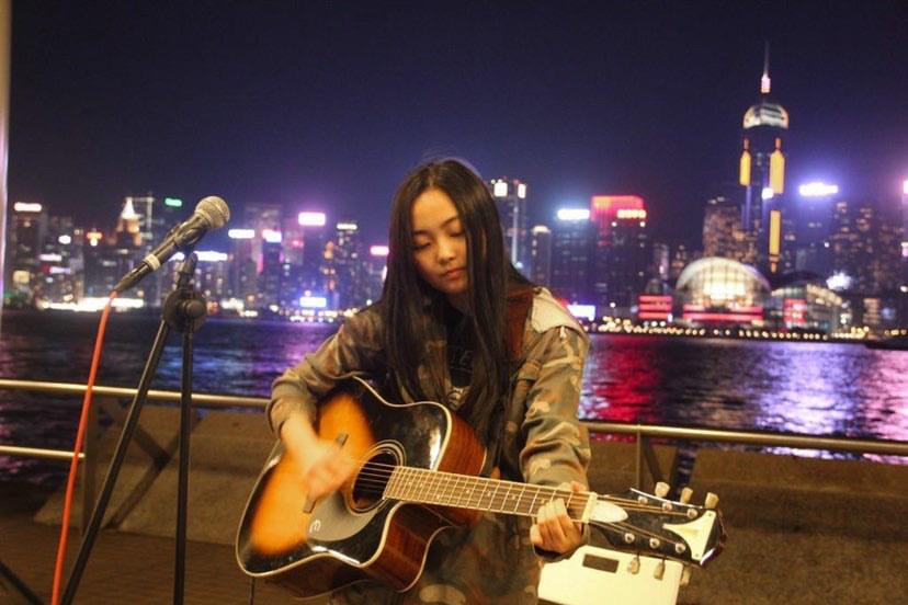Keung plays guitar while performing on the street in Hong Kong. Before the COVID-19 pandemic took full effect, Keung and her friends would often busk and play music at local bars.