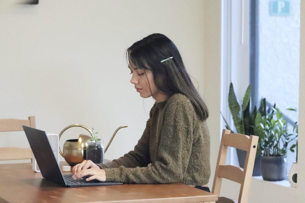 Senior Danielle Aro completes her online work in front of her plant garden at her apartment in Calabasas. Aro reconnected with friends this semester but said she thought remote classes weakened the overall sense of Pepperdine community. Photo by Ali Levens