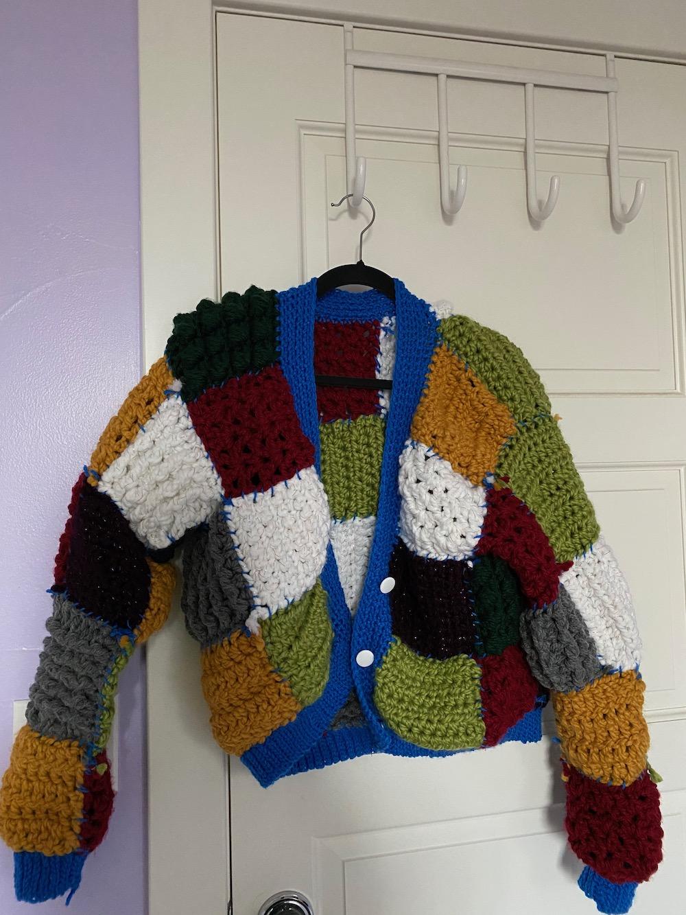 Senior Aracelli Chang's crocheted replica of the Harry Styles cardigan hangs in her room after its completion at the end of August. After postponing her graduation by a semester, Chang said she hopes to continue her hobbies during her time off from school. Photo courtesy of Aracelli Chang