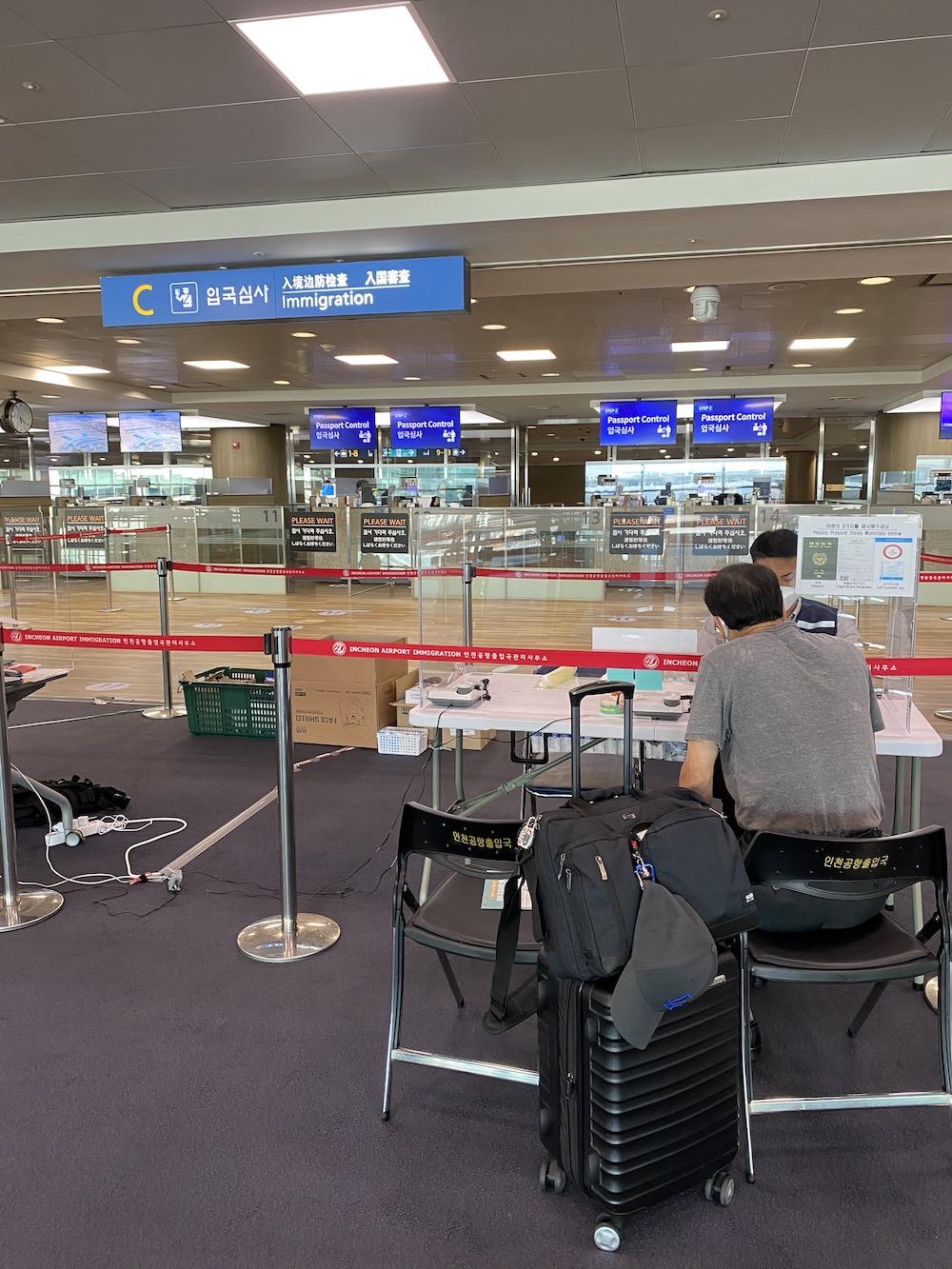 A quarantine-facilitating official checks a man's forms in the Incheon International Airport in South Korea. The man sat with his luggage at the second station at 5:20 p.m.