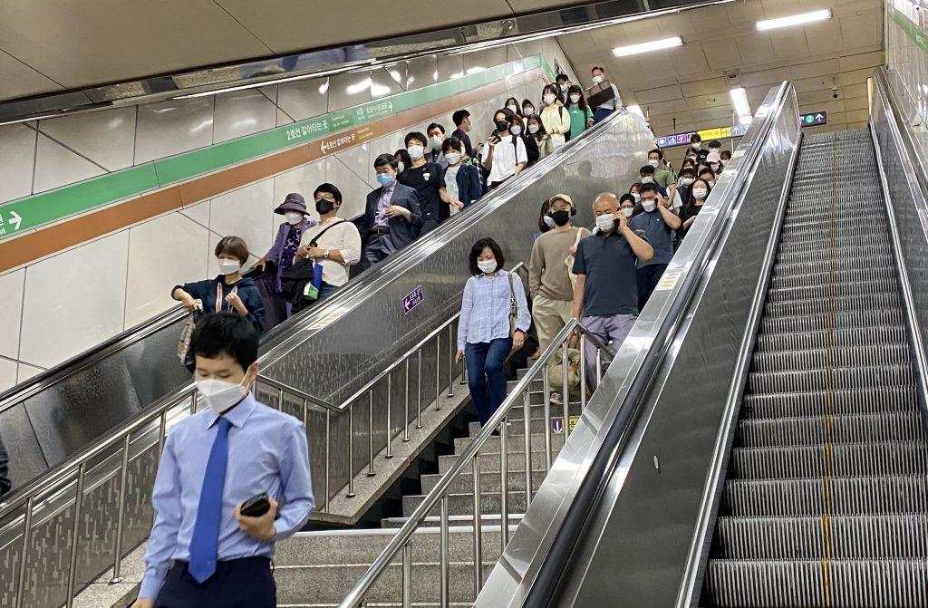A crowd of public-transit users exit one subway and transfer to another subway line at Hapjeong Station. People continued to wear face masks Sept. 25, which was almost two weeks after the social distancing level was brought down.