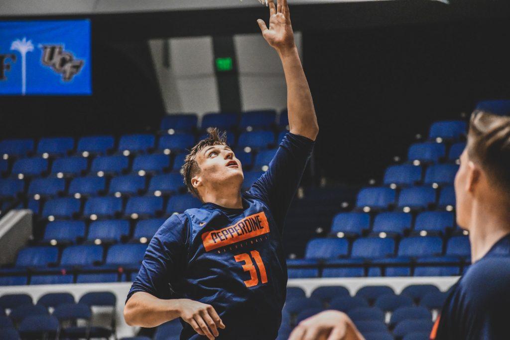Sophomore forward Jan Zidek softly reaches to lay the ball on the rim for an easy two while warming up for a Wooden Legacy tournament game Nov. 25, 2019. Zidek played sparingly last season but may have a much larger role this year. Photo courtesy of Morgan Davenport, Pepperdine Athletics