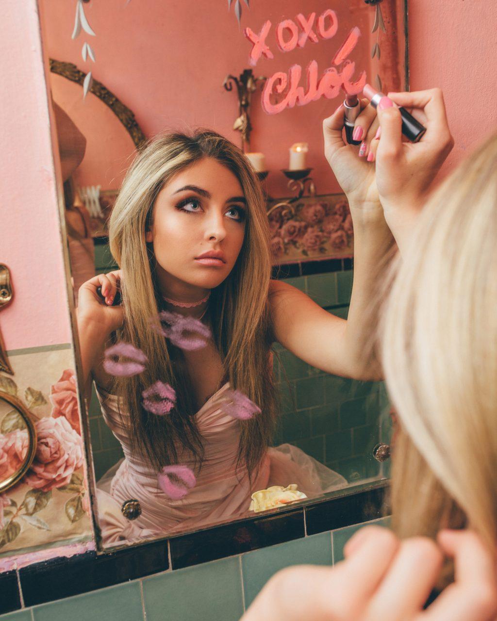 Boudames writes her name in lipstick on a mirror during a photoshoot at the Ragdoll Pink Palace in Los Angeles in March 2018. Boudames said her presence on social media has given her great opportunities. Photo courtesy of Chloe Boudames