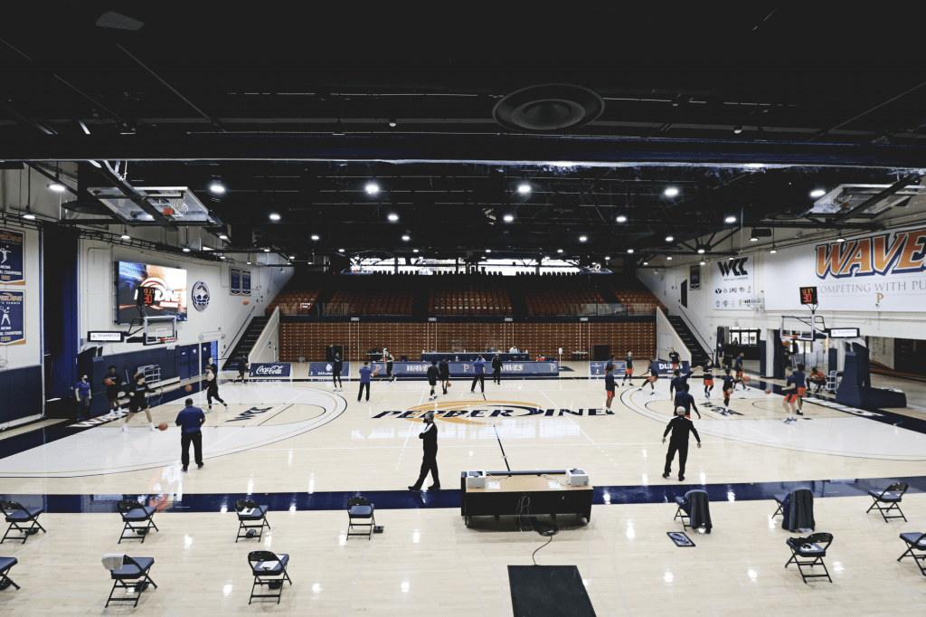 The Pepperdine Waves (right) warm up opposite of the Pilots for another fanless game in Firestone Fieldhouse on Jan. 16. ///I think it would be cool to include how many games were fanless in Firestone this year, if you end up using this photo///
