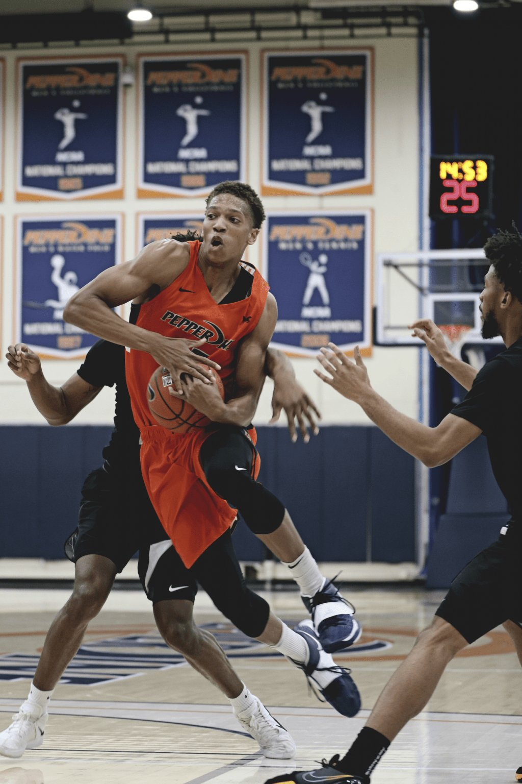 Junior forward Kessler Edwards grips the ball to prepare for a left-handed layup while two Portland defenders close in on the first-quarter scoring attempt.