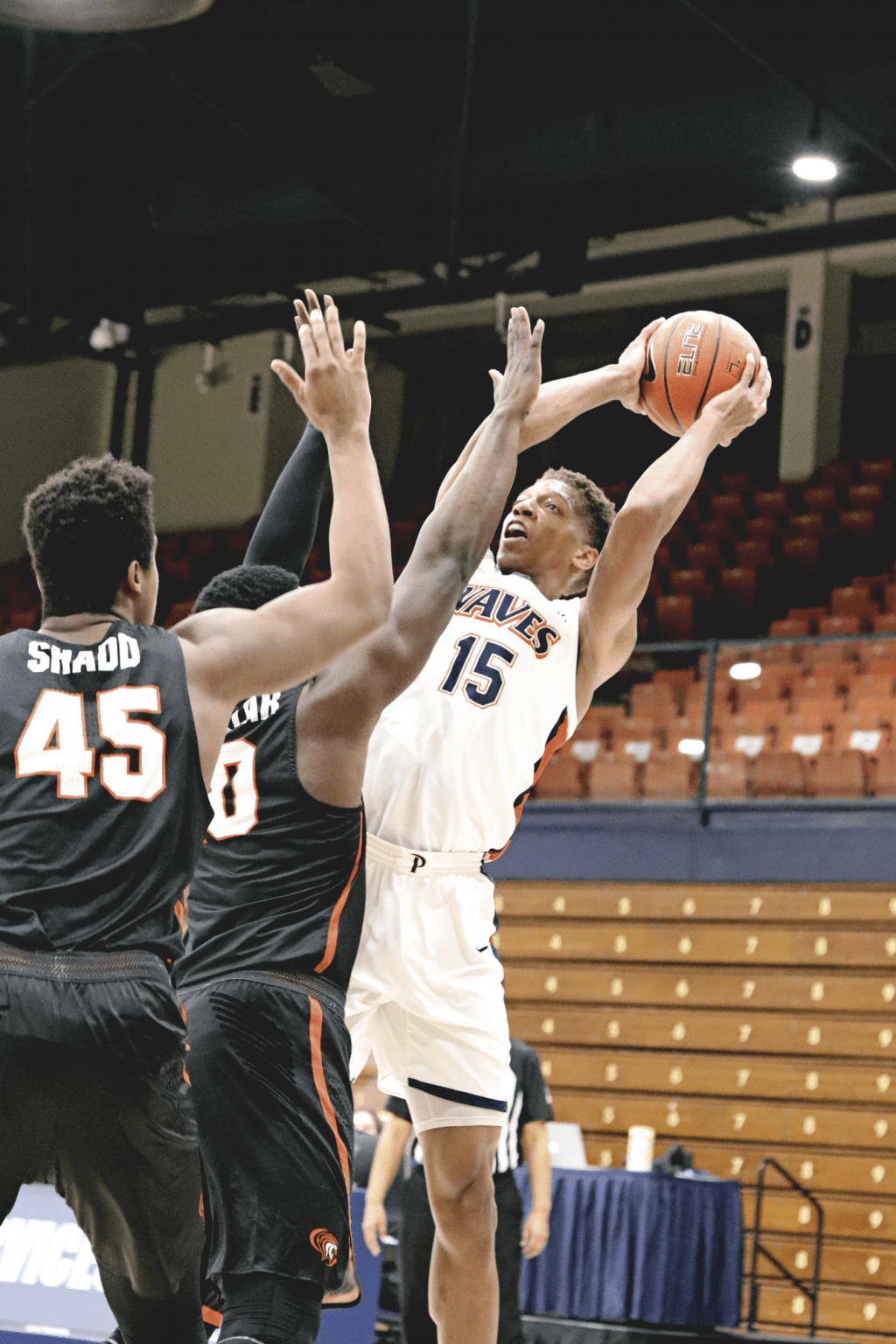 Edwards arches back for a baseline jump shot while Pacific defenders Jonathan Salazar and Nigel Shadd close out.