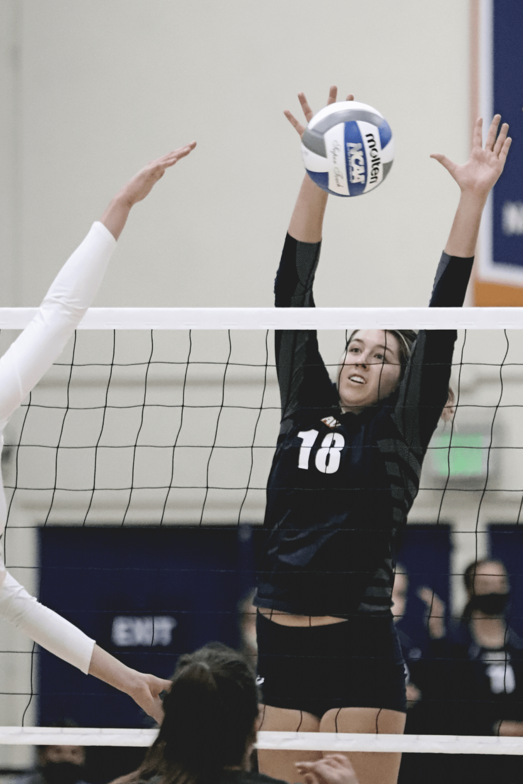 Junior opposite Rachel Ahrens reaches for a block against a USF outside hitter in the first set.