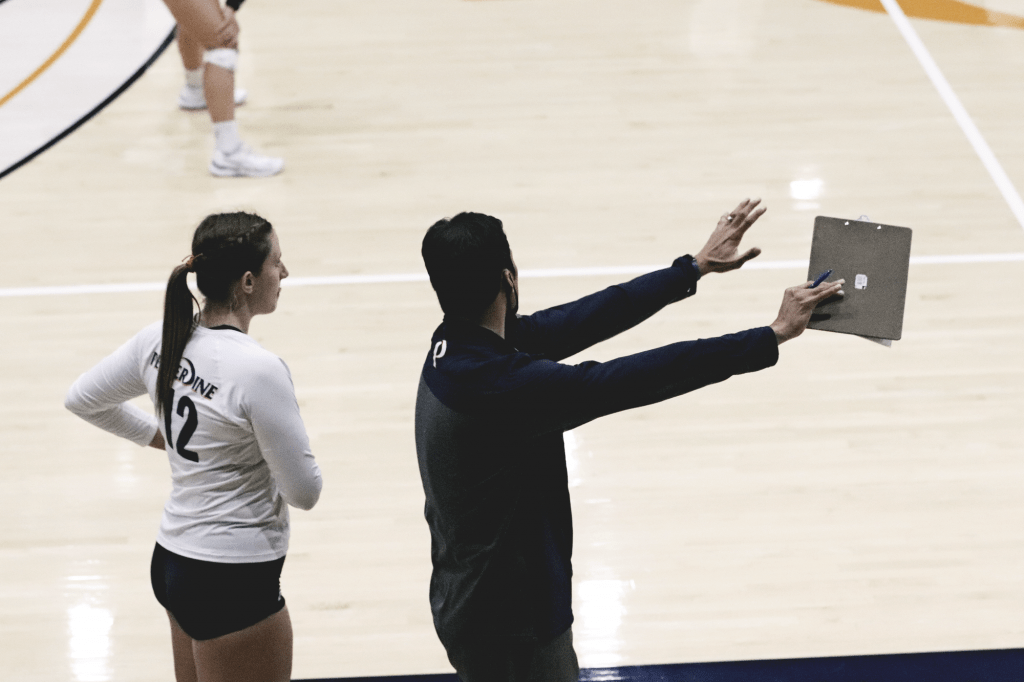 Brown (left) receives instruction from Head Coach Scott Wong (right) at Firestone Fieldhouse on Feb. 16. Brown has been a strong force for the Waves during her freshman year.