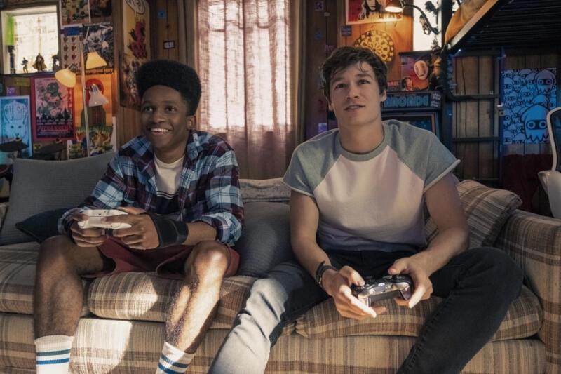 Mark (right) and his friend Henry (Jermaine Harris) play video games. Mark told him about the time loop, but Henry does not understand the idea of it.