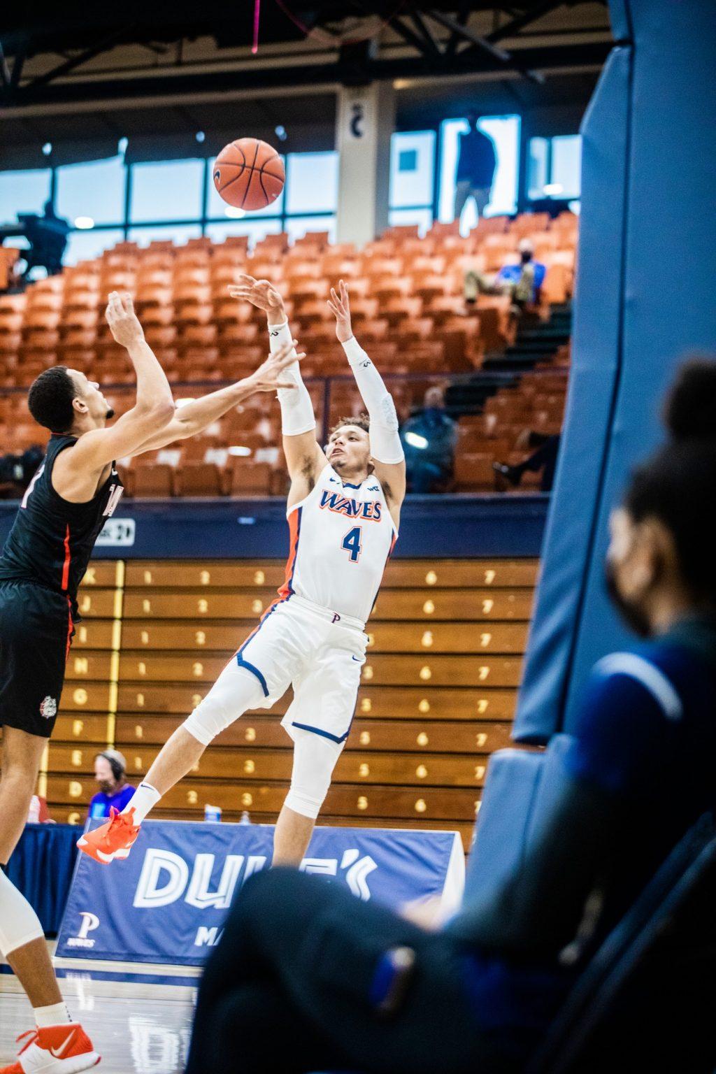 Pepperdine senior point guard Colbey Ross attempts a fadeway jump shot over Gonzaga's Jalen Suggs during the first half Saturday at Firestone Fieldhouse. Ross finished with 16 points in the game, surpassing 2,000 points in his Pepperdine career along the way.