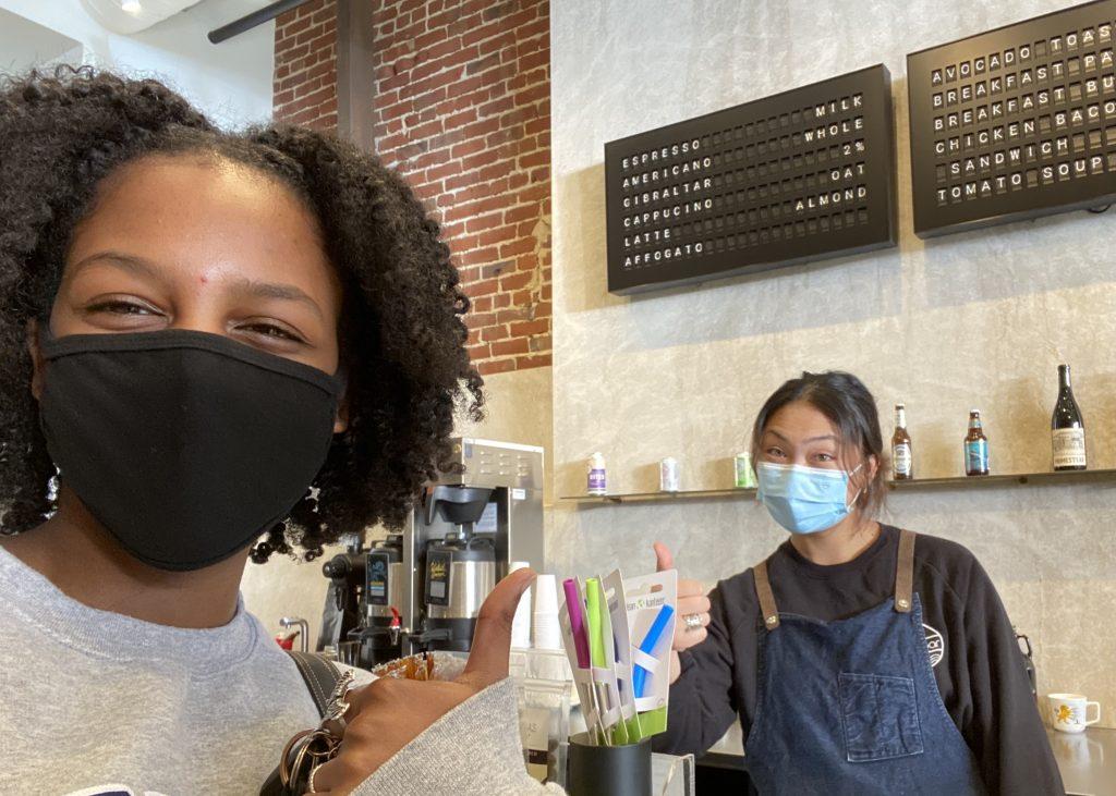 Abaya (right) smiles as her friend visits her at work in January, in Redwood City. She said her go-to drink is a cold brew, but she loves to make hot lattes with cool designs.