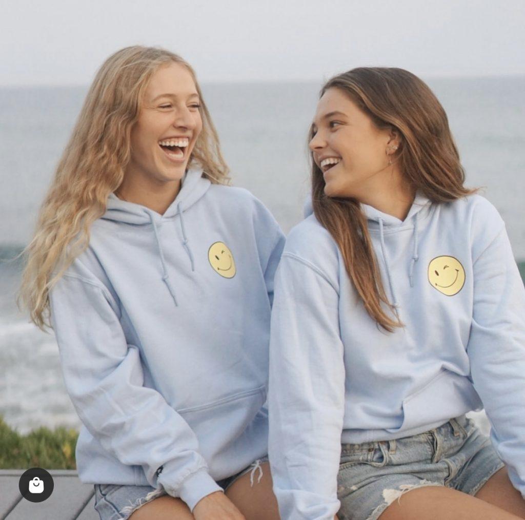 Gearhart's sorority sisters, first-year Alexa Wright (left) and Huff (right), laugh while wearing their smiley face sweatshirts in Malibu in September. After moving to Malibu, Gearhart said the location made it easy to take promotional photos and it was nice having her friends by her side.
