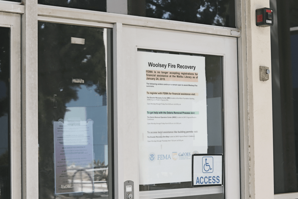 A Woolsey Fire Recovery poster dons a door panel at the Malibu Courthouse on March 24. Since the Woolsey Fire of 2018, City Council streamlined the permit process for original homeowners to rebuild, saving residents more than $4.2 million to date.