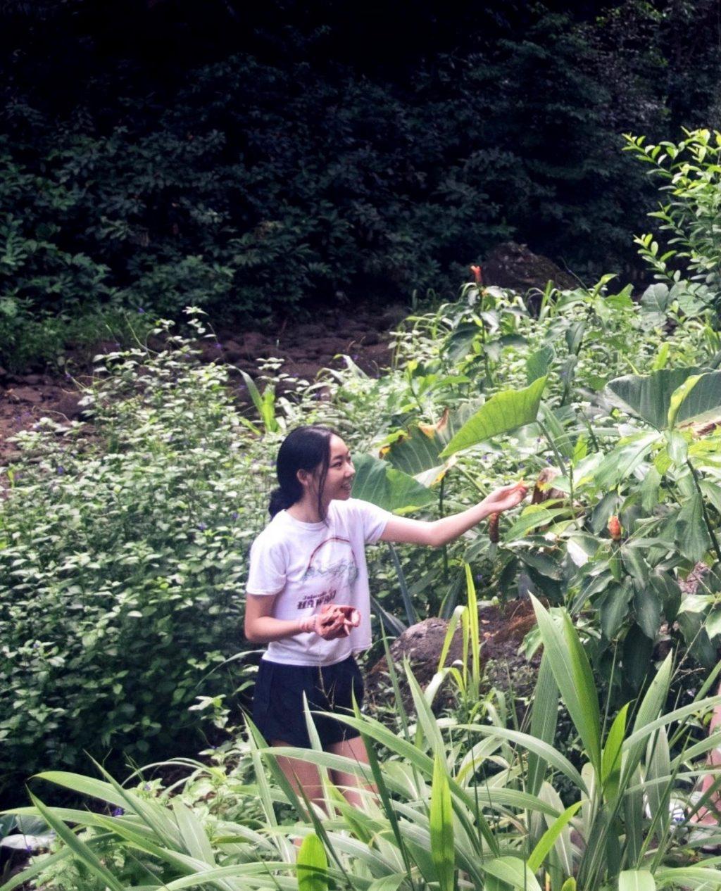 Elias takes a break from tending to the land to show her friends a beautiful flower in Waimea Valley, Hawai'i in July 2019. Elias said the service trip changed her life and strengthened her relationship with God.