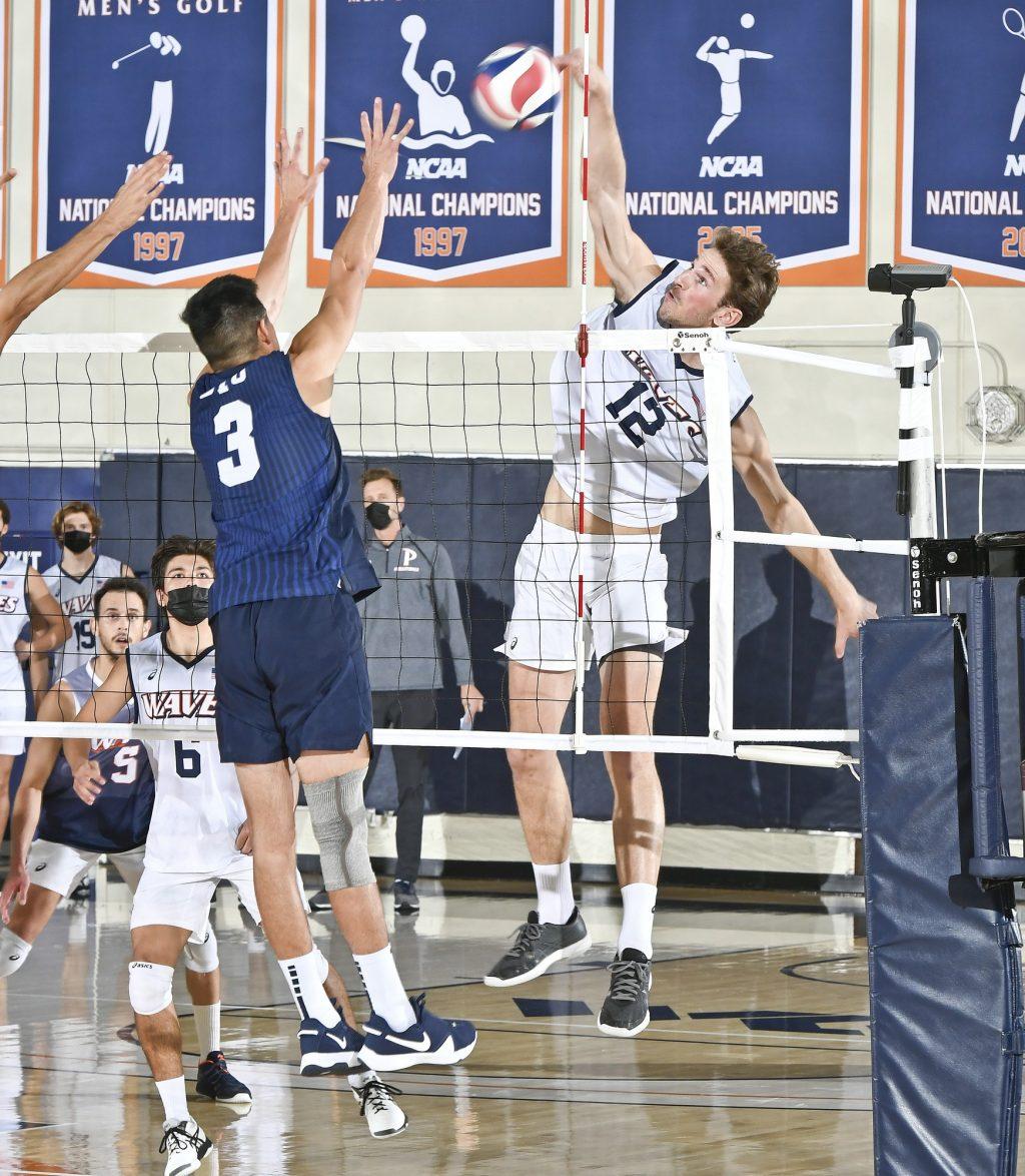 Redshirt sophomore outsider hitter Jacob Steele rolls the ball over BYU's Wil Stanley on Friday in Firestone Fieldhouse. Steele tallied nine kills in each match of the doubleheader. Photo Courtesy of Martin A. Folb | Pepperdine Athletics