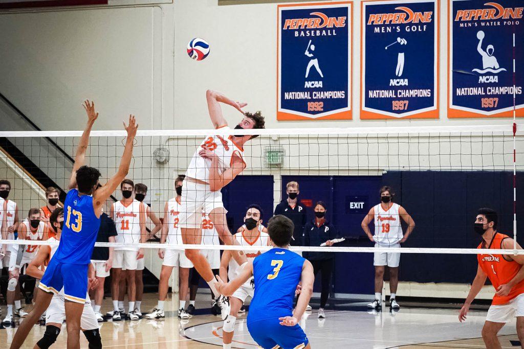 Redshirt senior middle blocker Austin Wilmot slams down a hit against a late UCLA block. Wilmot had an astounding 12 kills and 9 blocks during Saturday's match, earning himself the team's golden wrestling belt, the Mountain Pacific Sports Federation for Defensive Player of the Week and the American Volleyball Coach's Association's National Player of the Week.