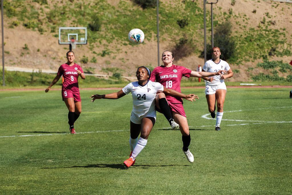 Freshman midfielder Julianna Duckett (No. 24) muscles with a defender for control of the ball during Tuesday's match. The Waves and the Broncos continued their traditional rivalry with a nail-biting game that needed double overtime.