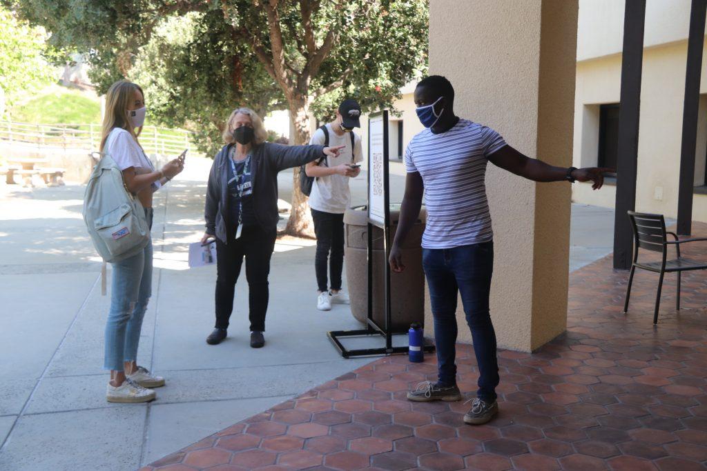 A student checks in for her appointment reservation with a library employee at Payson Library on Feb. 24. Pepperdine libraries have posted guidelines at the front of each facility.