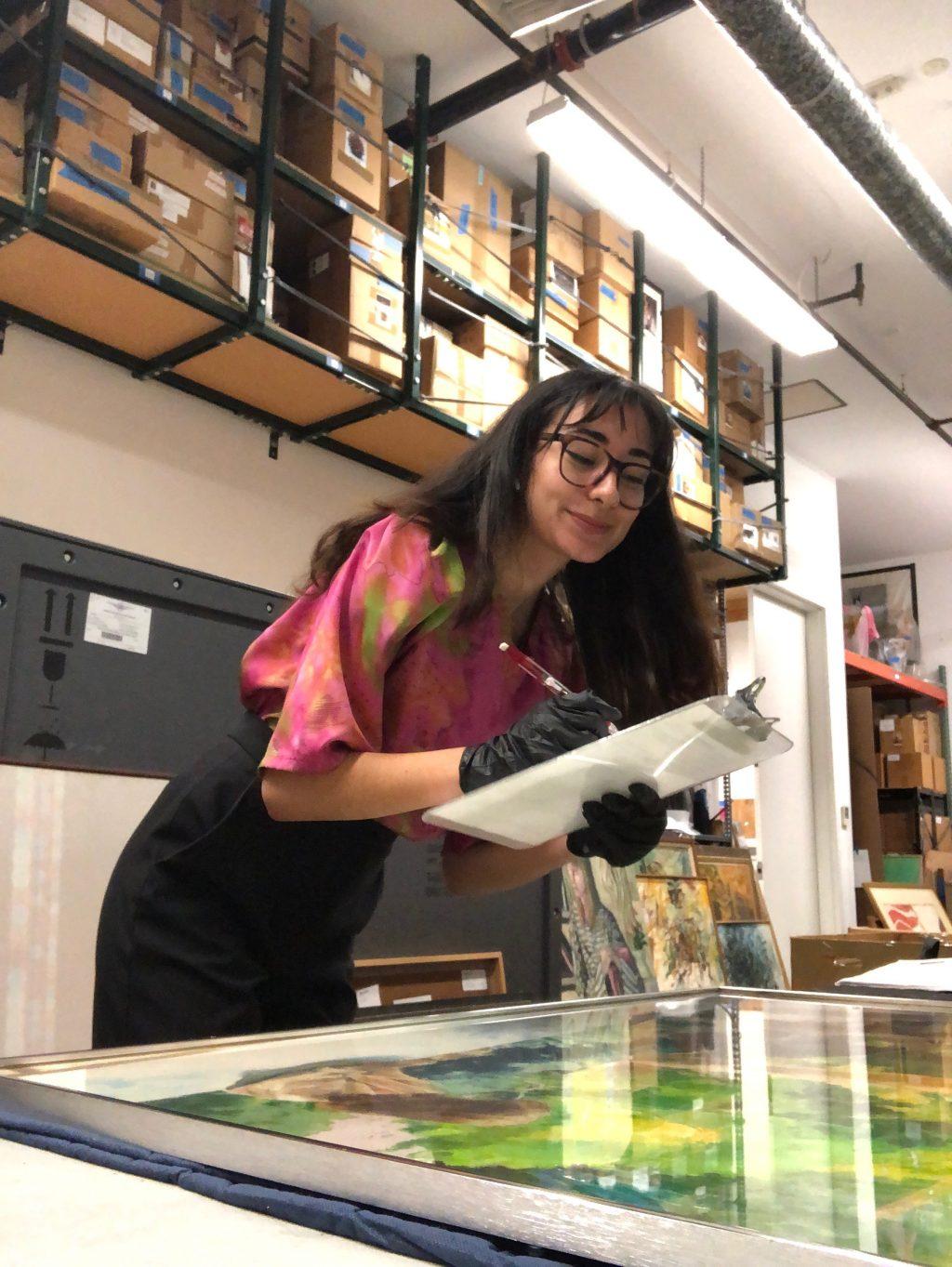Campbell writes down notes on a painting during her internship in July 2019 at the Long Beach Museum of Art. Campbell said she learned a lot about museum work and local artists through her jobs at both the Long Beach Museum of Art and the Weisman Museum of Art on the Malibu campus.