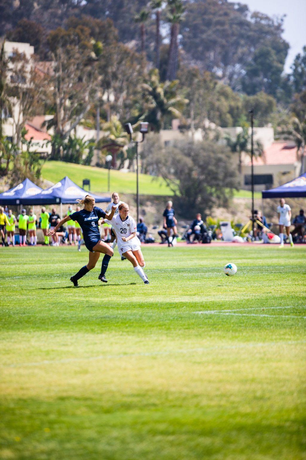 Freshman forward Tori Waldeck delivers a composed finish from the top of the penalty area as San Diego freshman Katie Baxter pursues. Waldeck's goal was Pepperdine's fifth in the first 19 minutes of the match and her fourth of the season.