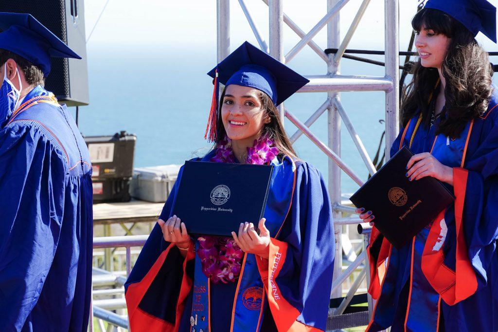 Alumna Carlie Ott holds her diploma case during the Class of 2020 commencement. The ceremony took place one year after the class graduated.